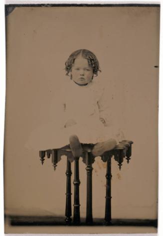 Portrait of a Child Seated on a Table