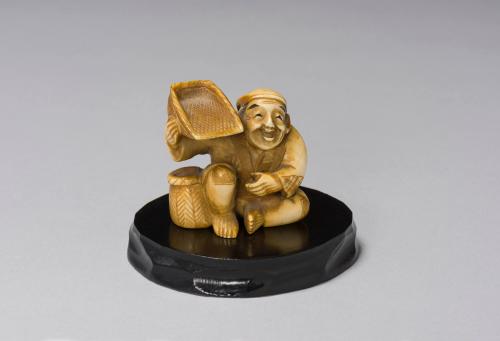 Netsuke: Squatting Man with Basket on Shoulder and Basket Beside Right Leg