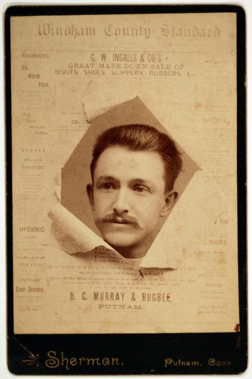 A Man Peering through a Torn Newspaper