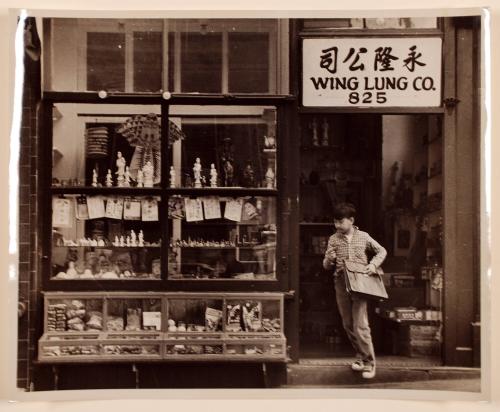 Boy in doorway of storefront, Chinatown, San Francisco